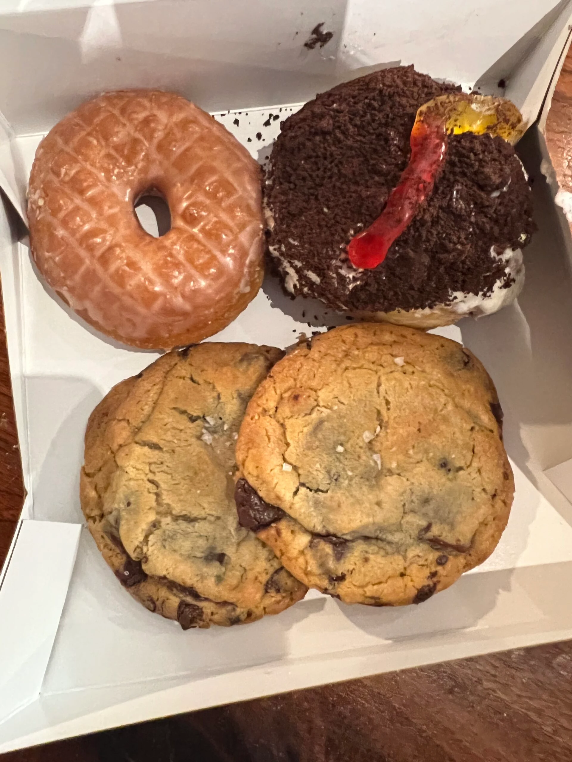 two chocolate chip cookies and two donuts in a box