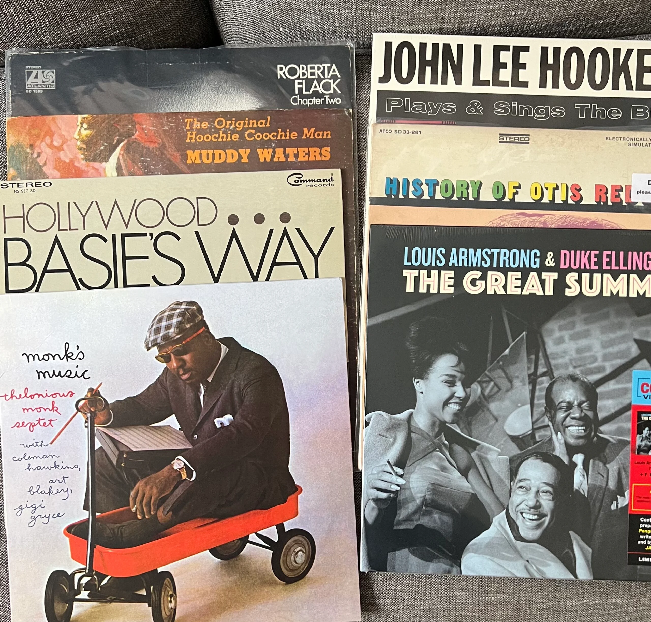 collection of records splayed out inlucding louis armstrong, thelonious monk, john leek hooker and count basie